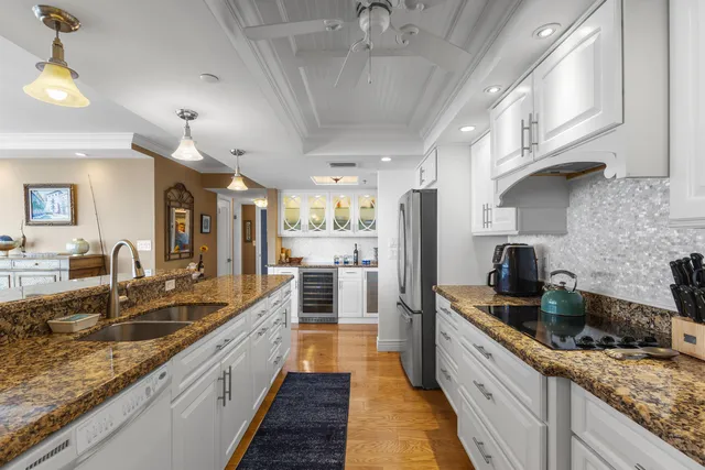 a large kitchen with stainless steel appliances granite countertop a lot of counter space and a sink