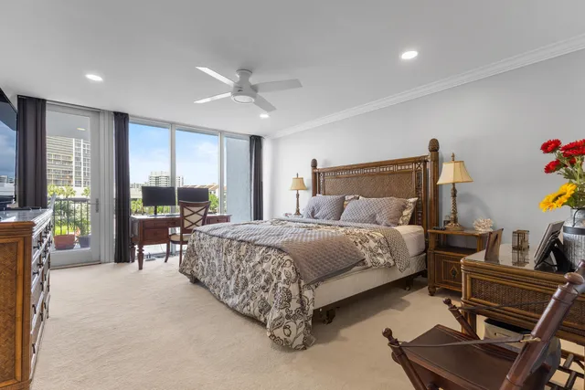 a bedroom with a bed and large windows