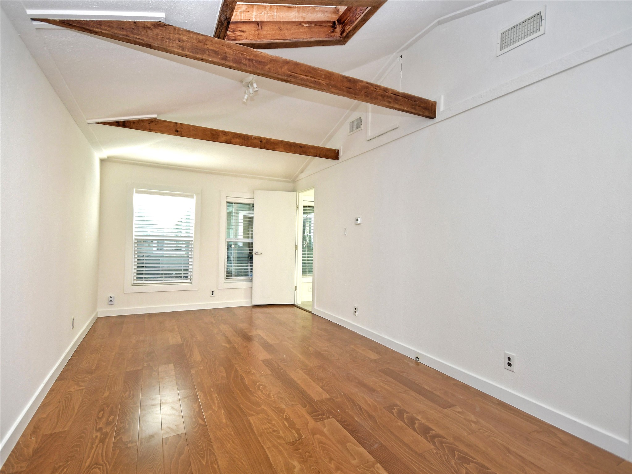 4604 Red River Street, Unit B Austin, TX 78751 - Photo 5 of 15 Varnished wood flooring pairs with exposed beams in this spacious, well-lit room.