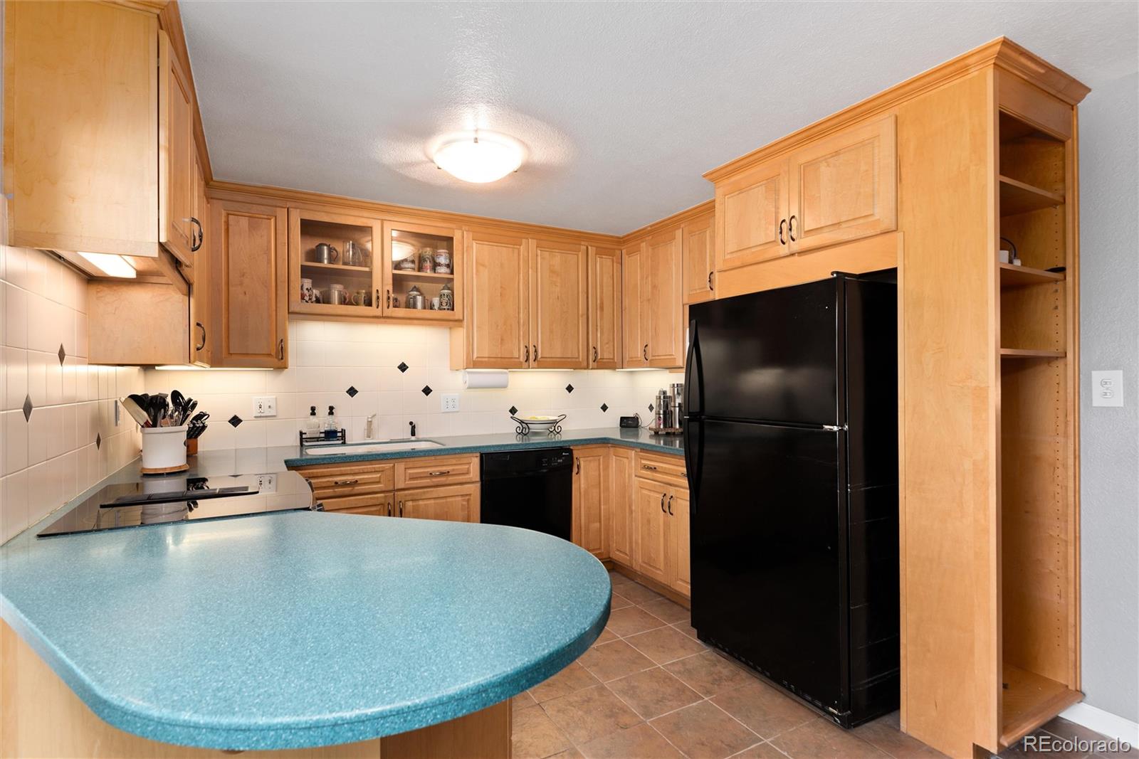4904 West 61st Drive Arvada, CO 80003 - Photo 11 of 37 a kitchen with stainless steel appliances granite countertop a sink stove and refrigerator