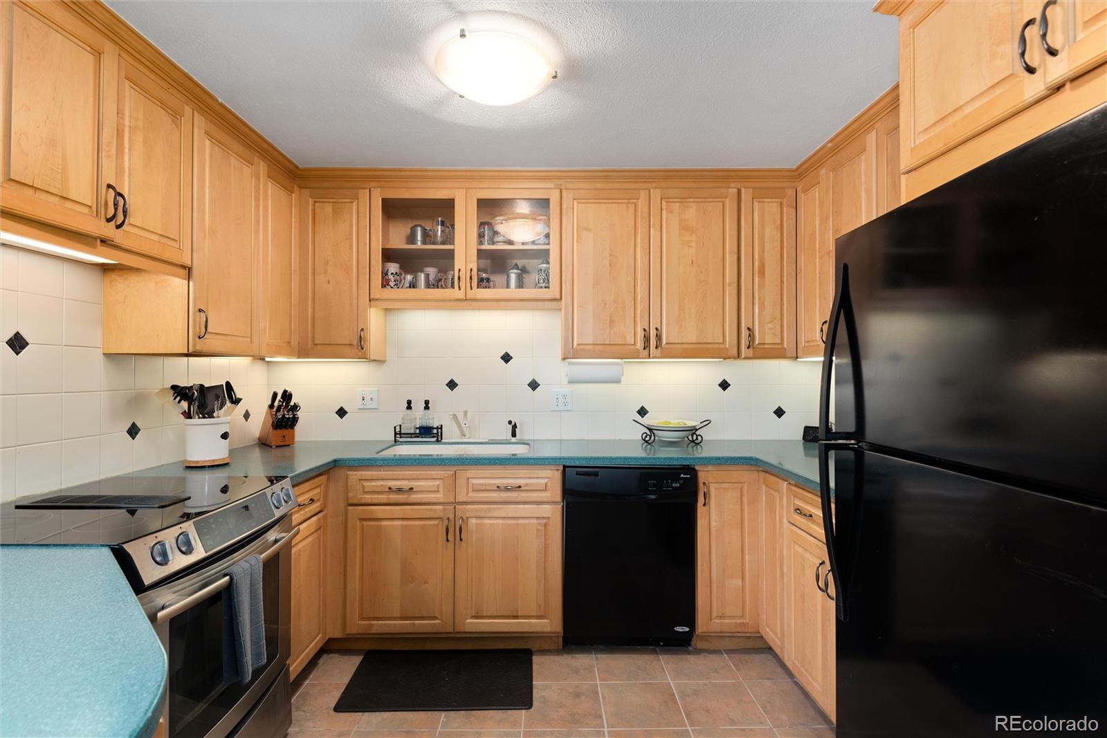 4904 West 61st Drive Arvada, CO 80003 - Photo 12 of 37 a kitchen with a sink stove and refrigerator