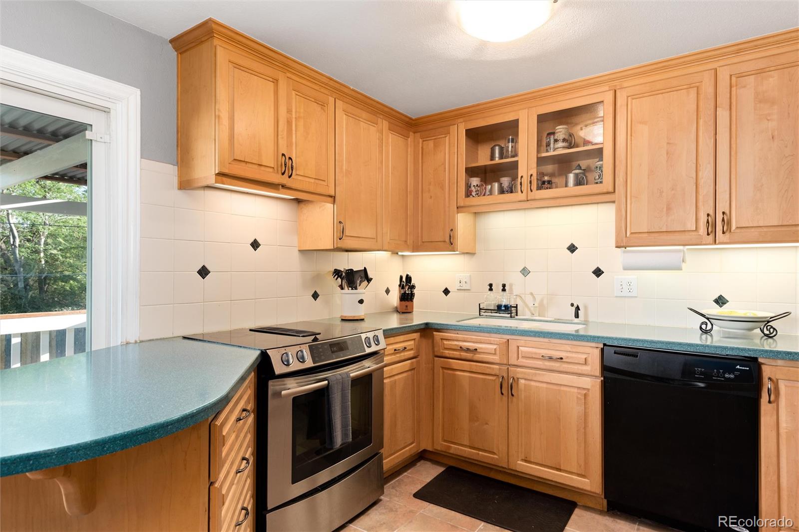 4904 West 61st Drive Arvada, CO 80003 - Photo 13 of 37 a kitchen with stainless steel appliances granite countertop a sink stove and cabinets