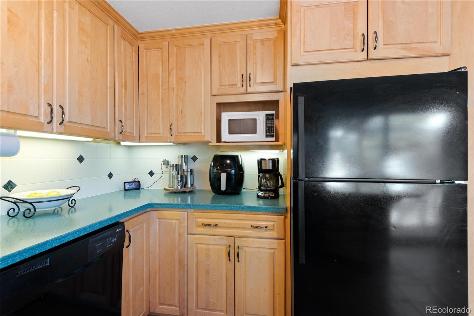 4904 West 61st Drive Arvada, CO 80003 - Photo 14 of 37 a kitchen with a refrigerator and cabinets