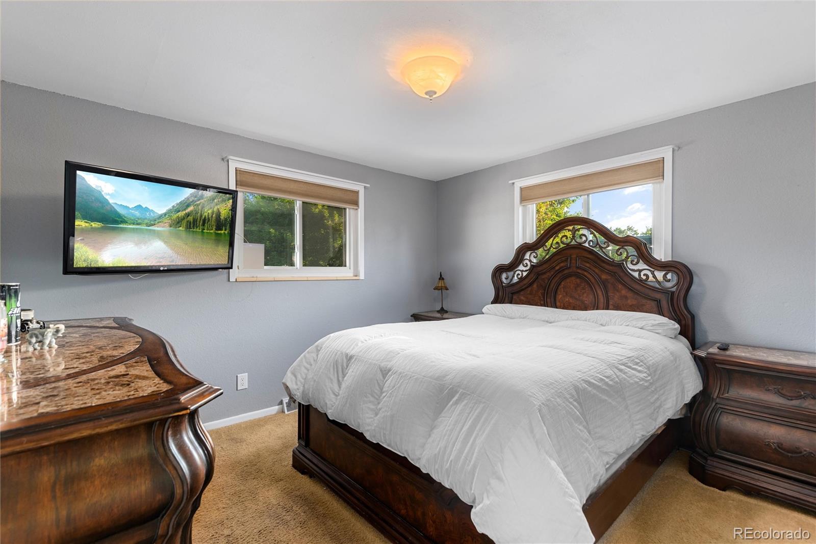 4904 West 61st Drive Arvada, CO 80003 - Photo 15 of 37 a bedroom with a bed and a flat screen tv