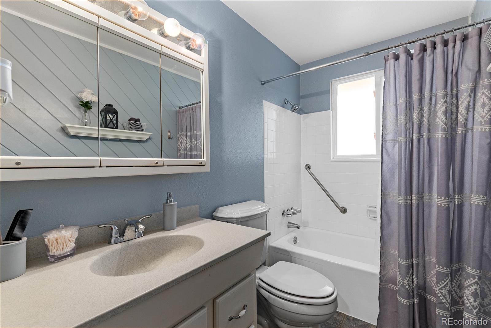 4904 West 61st Drive Arvada, CO 80003 - Photo 17 of 37 a bathroom with a sink a toilet and shower