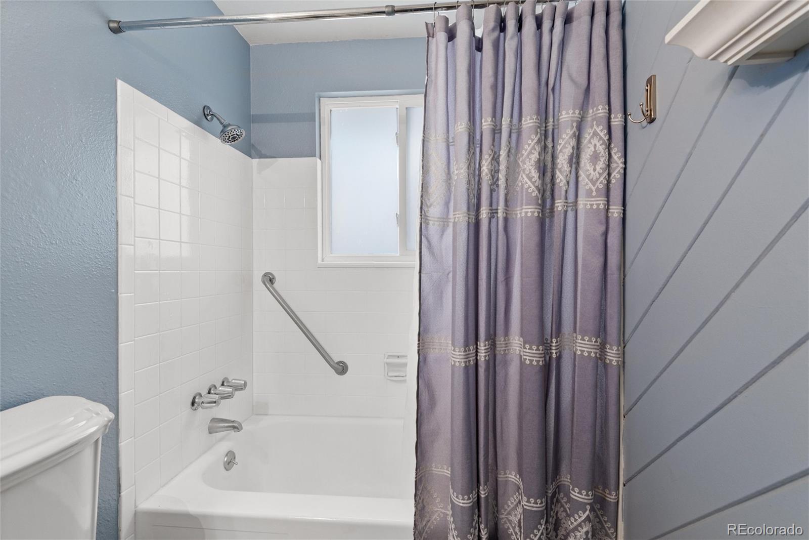 4904 West 61st Drive Arvada, CO 80003 - Photo 18 of 37 a bathroom with a bathtub and a shower