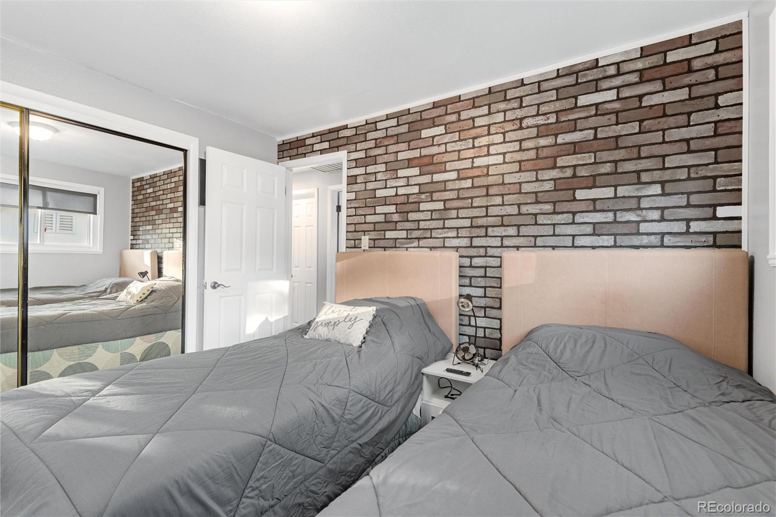 4904 West 61st Drive Arvada, CO 80003 - Photo 20 of 37 a bed sitting in a bedroom next to a bathroom