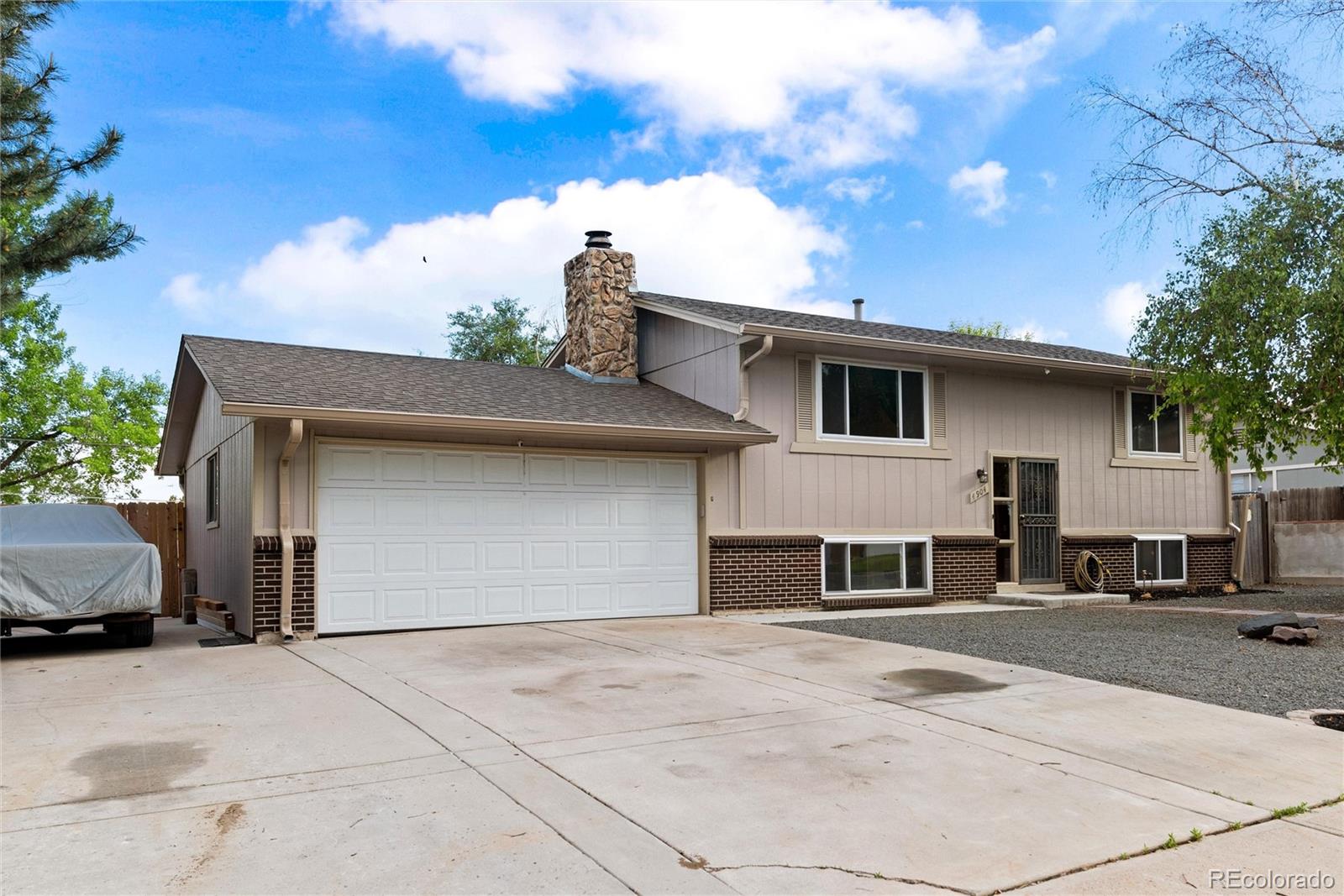 4904 West 61st Drive Arvada, CO 80003 - Photo 2 of 37 a front view of a house with a yard and garage