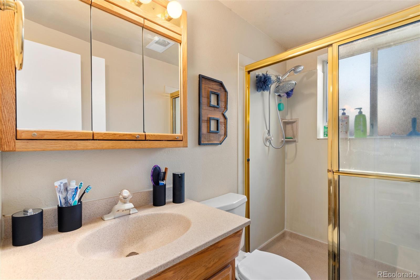 4904 West 61st Drive Arvada, CO 80003 - Photo 28 of 37 a bathroom with a sink and a mirror