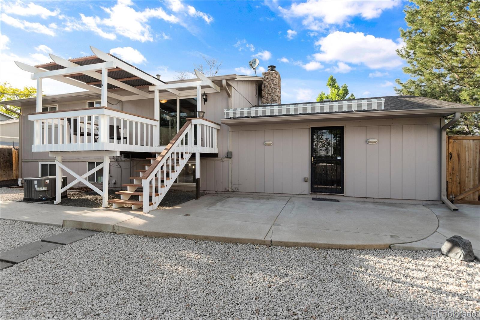 4904 West 61st Drive Arvada, CO 80003 - Photo 34 of 37 a view of a house with large windows and a small yard