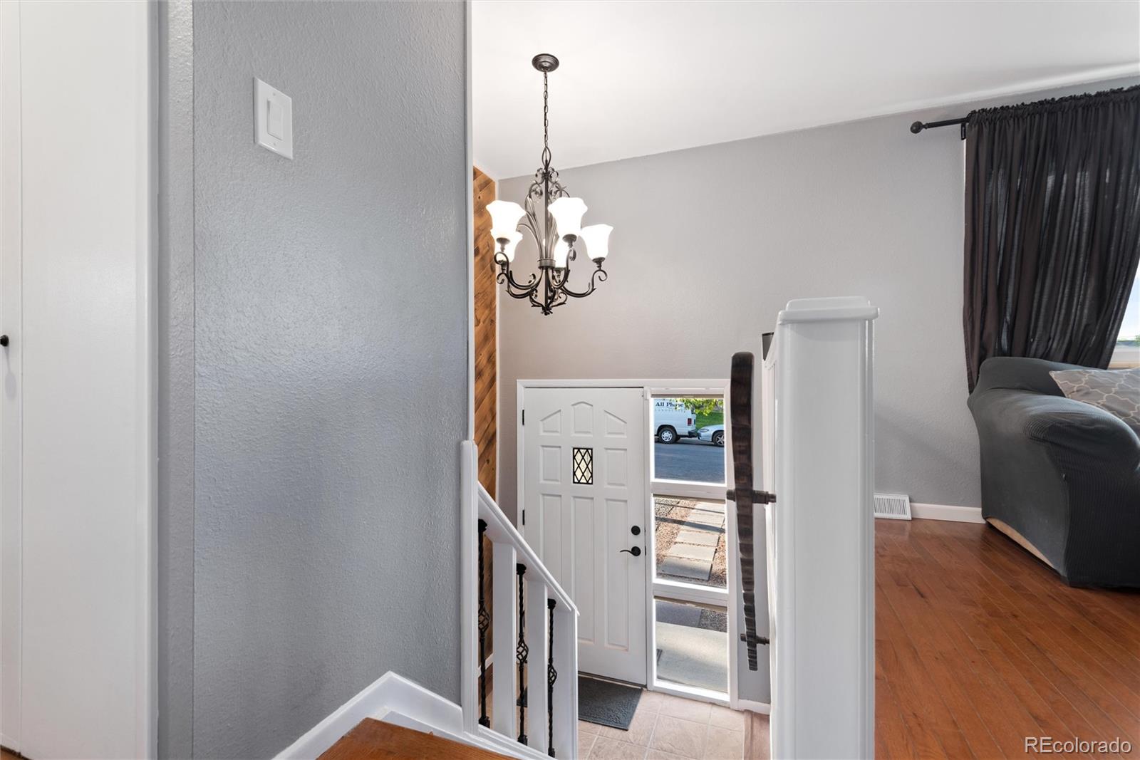 4904 West 61st Drive Arvada, CO 80003 - Photo 6 of 37 a view of a livingroom with a fireplace wooden floor and staircase
