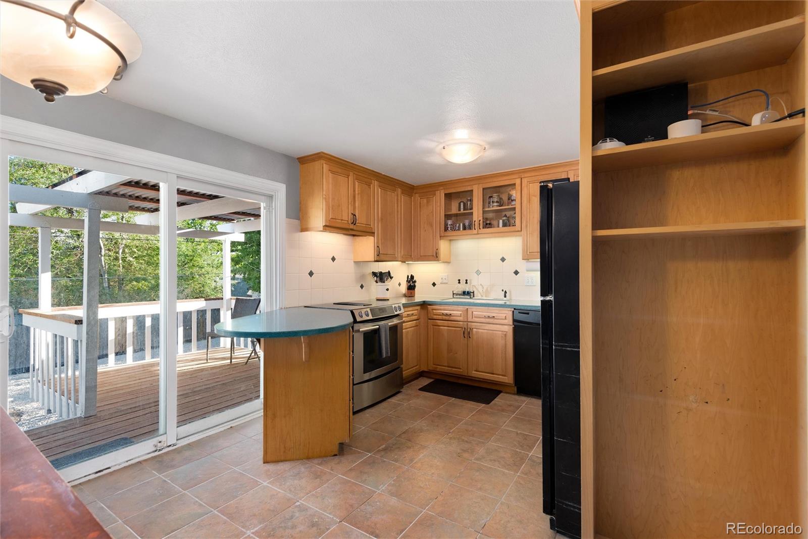 4904 West 61st Drive Arvada, CO 80003 - Photo 10 of 37 a kitchen with a sink refrigerator and cabinets