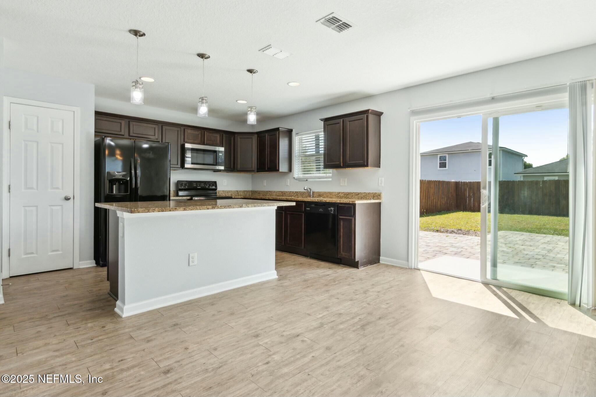 8414 Thor Street Jacksonville, FL 32216 - Photo 19 of 40 a large kitchen with stainless steel appliances granite countertop a stove and a sink