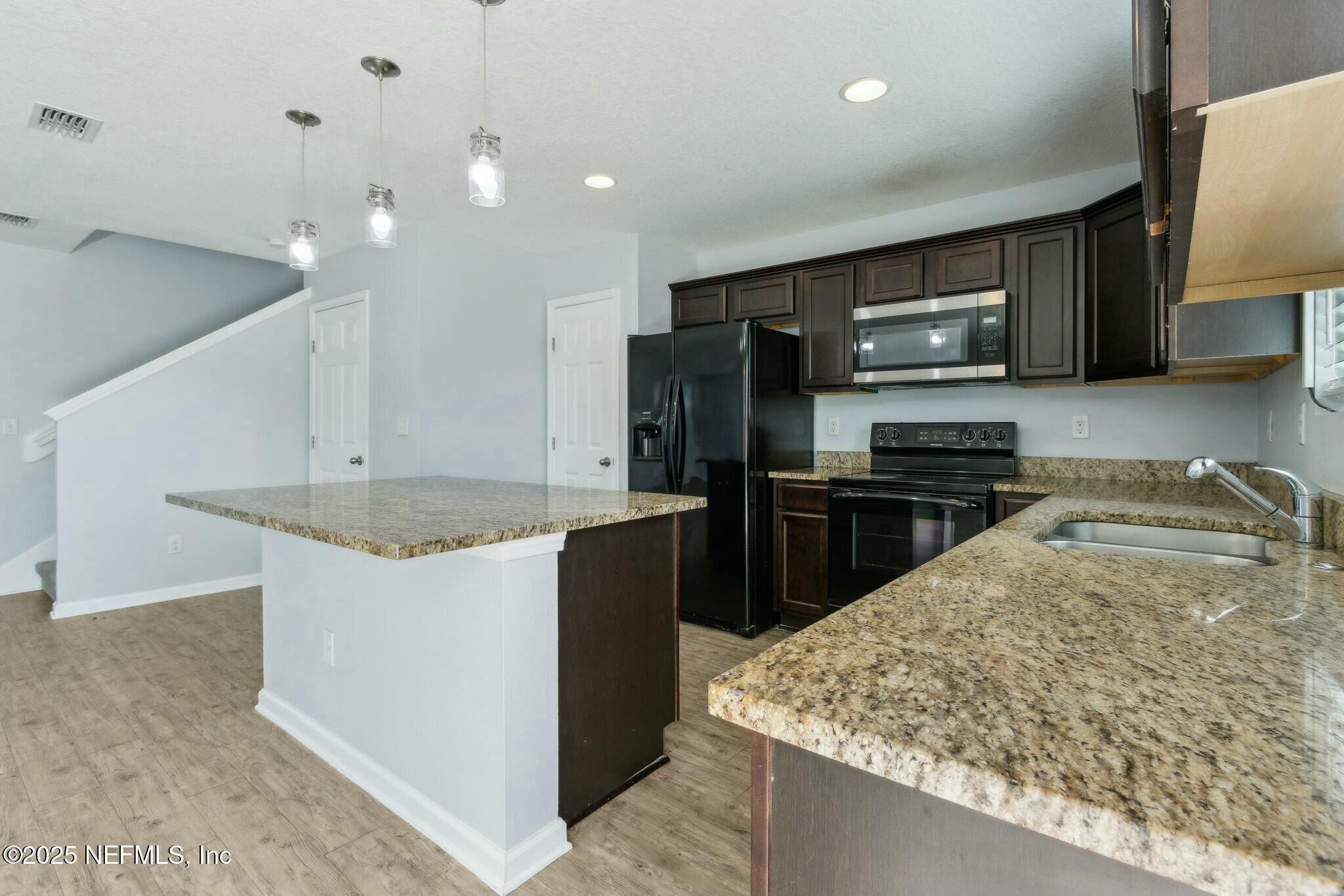 8414 Thor Street Jacksonville, FL 32216 - Photo 20 of 40 a kitchen with kitchen island sink stove and refrigerator