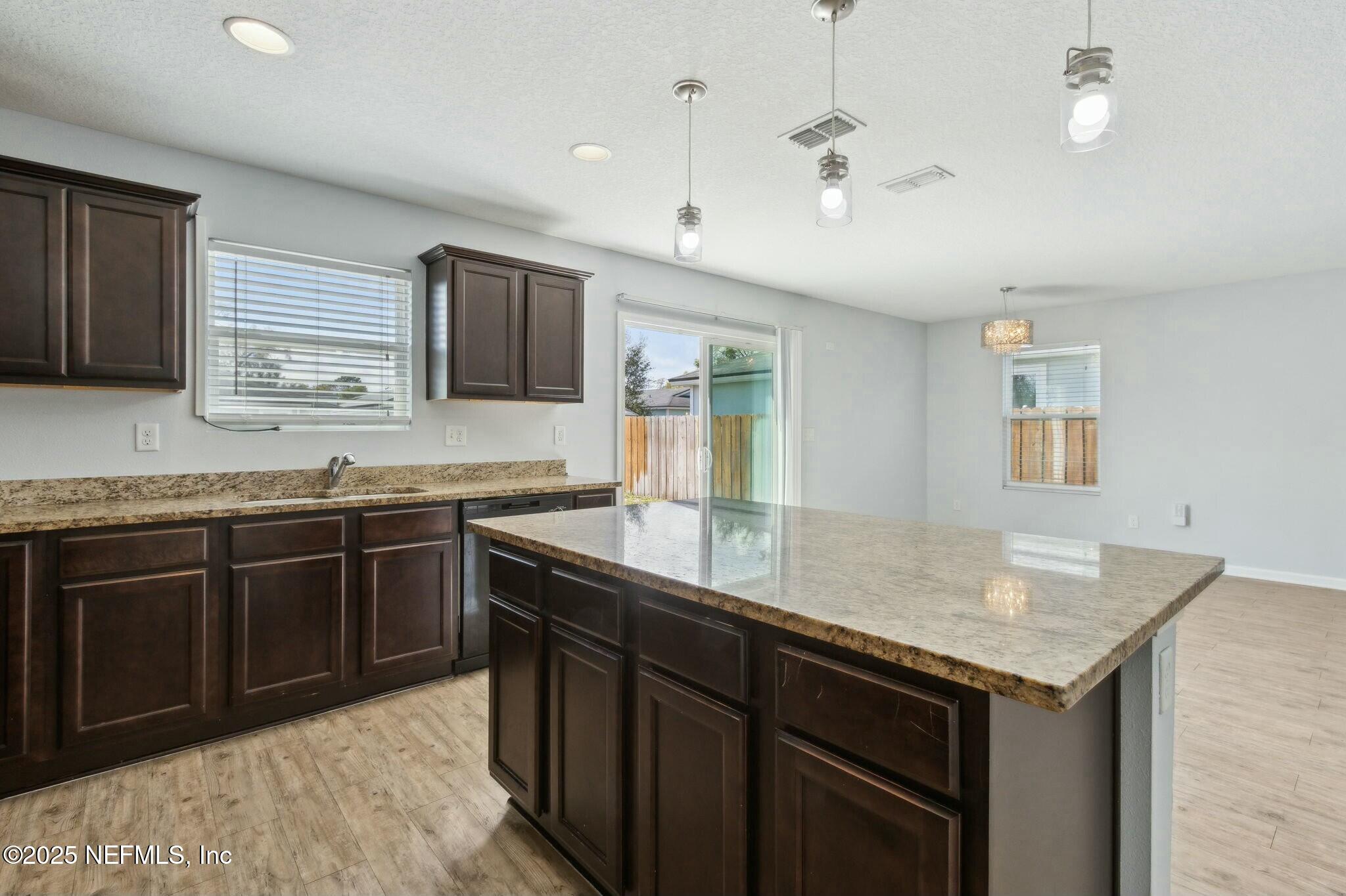 8414 Thor Street Jacksonville, FL 32216 - Photo 22 of 40 a kitchen with granite countertop a sink cabinets and window