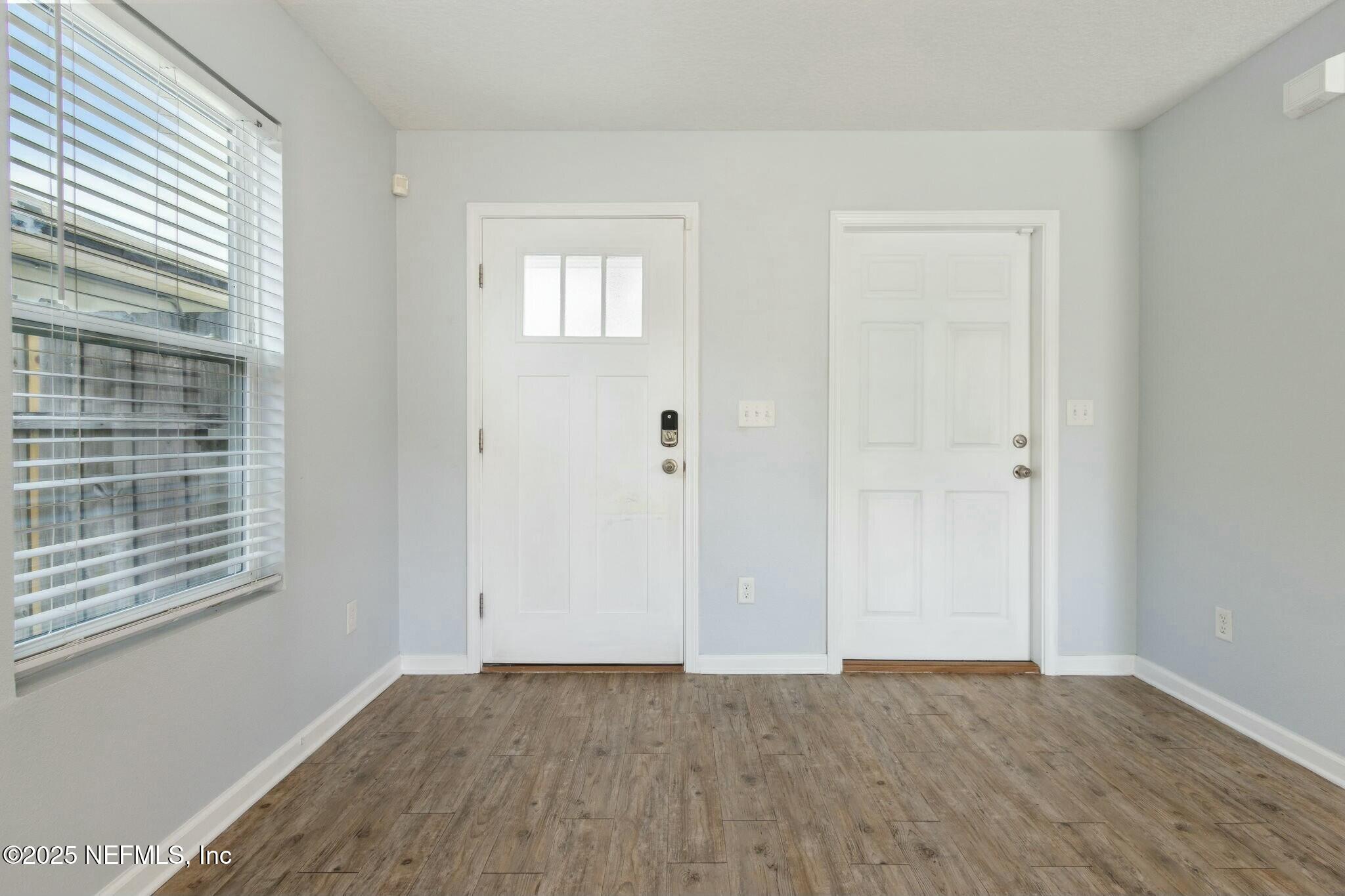 8414 Thor Street Jacksonville, FL 32216 - Photo 9 of 40 a view of an empty room with wooden floor and a window
