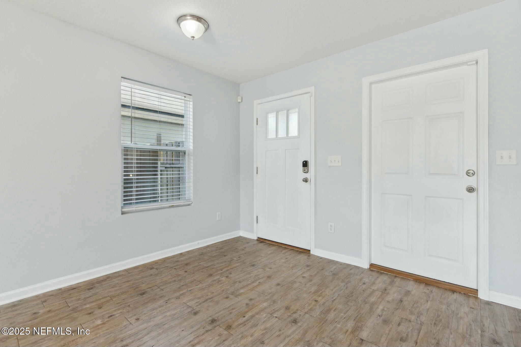 8414 Thor Street Jacksonville, FL 32216 - Photo 10 of 40 a view of an empty room with wooden floor and a window