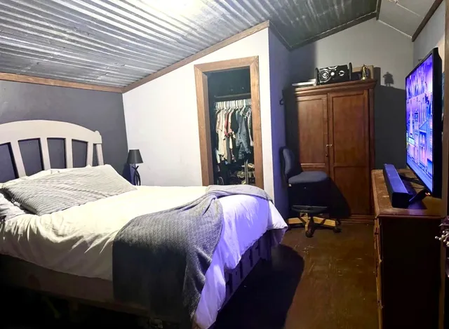 a bedroom with a bed and a flat tv screen