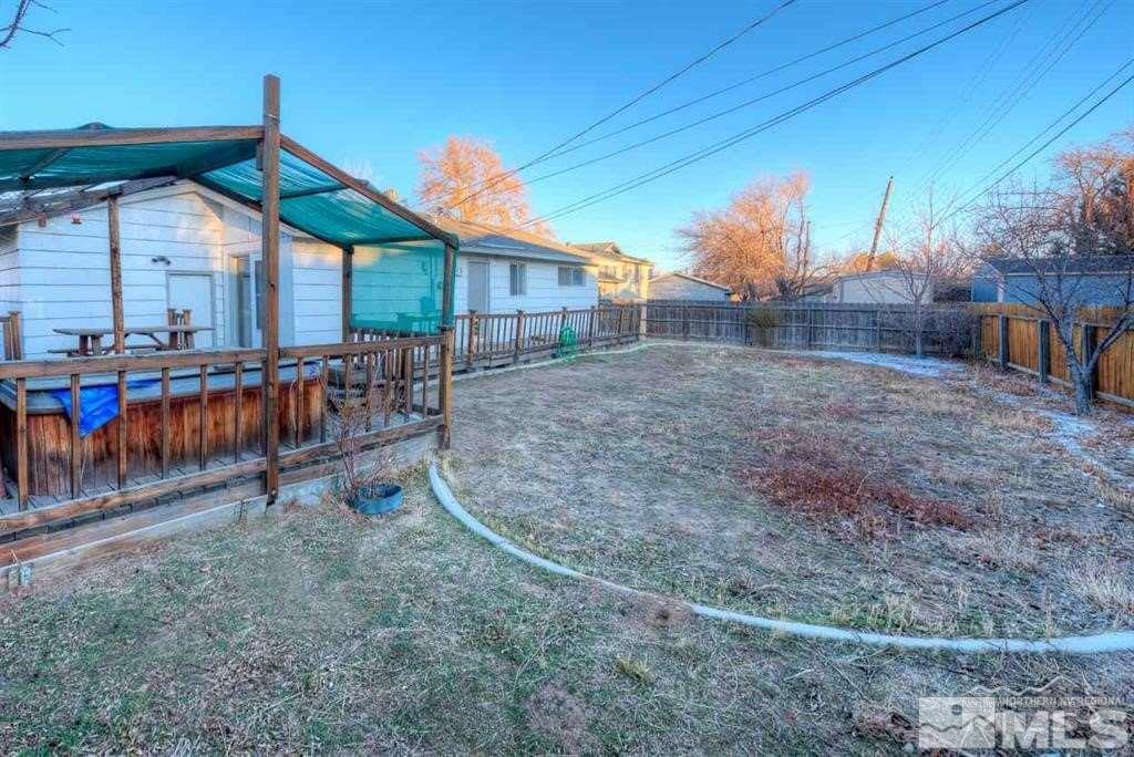 3245 Everett Drive Reno, NV 89503 - Photo 17 of 19 a view of a patio with table and chairs under an umbrella with wooden fence