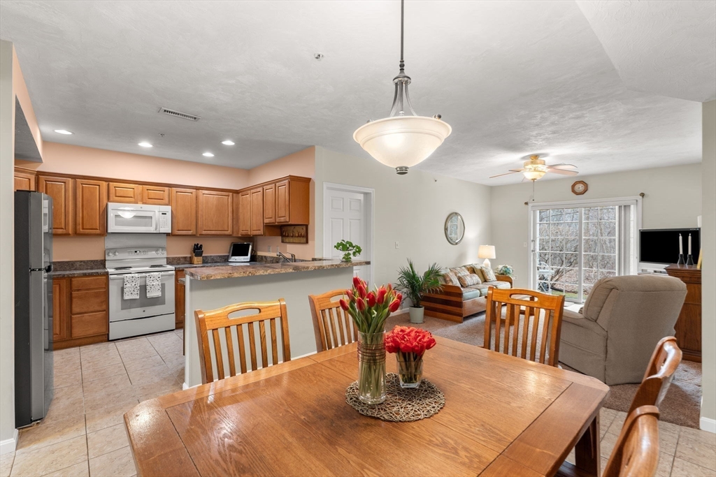 237 Salem Street, Unit 2 Reading, MA 01867 - Photo 11 of 34 a kitchen with stainless steel appliances granite countertop a dining table and chairs