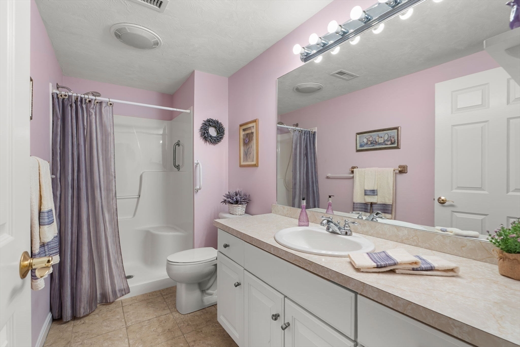 237 Salem Street, Unit 2 Reading, MA 01867 - Photo 21 of 34 a bathroom with a granite countertop sink toilet mirror and shower