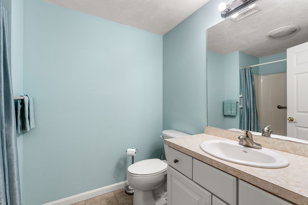 237 Salem Street, Unit 2 Reading, MA 01867 - Photo 25 of 34 a bathroom with a granite countertop sink toilet and mirror