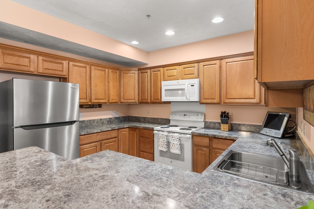 237 Salem Street, Unit 2 Reading, MA 01867 - Photo 6 of 34 a kitchen with stainless steel appliances granite countertop a refrigerator stove top oven and sink