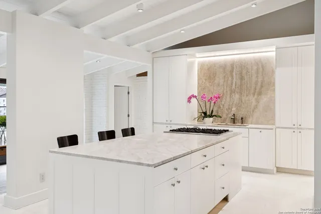 a kitchen with granite countertop white cabinets and white appliances