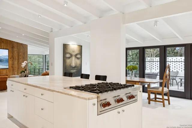 a kitchen with stove and large window