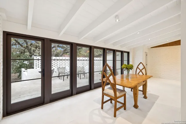 a dining room with furniture and a floor to ceiling window