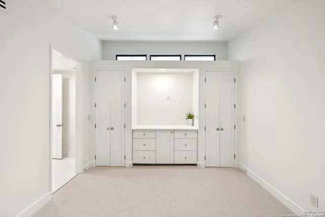 an empty room with windows and closet