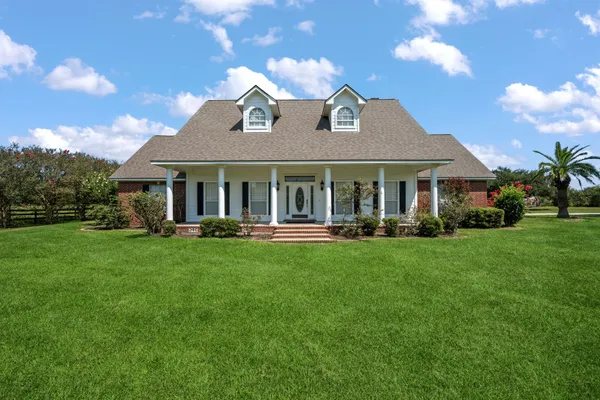 a front view of a house with yard and green space