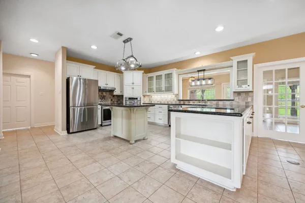 a kitchen with stainless steel appliances granite countertop a refrigerator and a stove