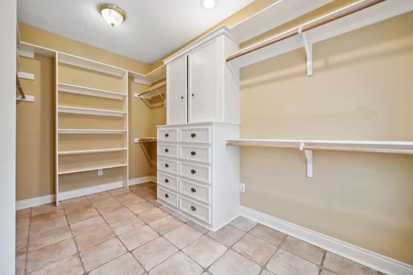 a view of walk in closet with empty racks