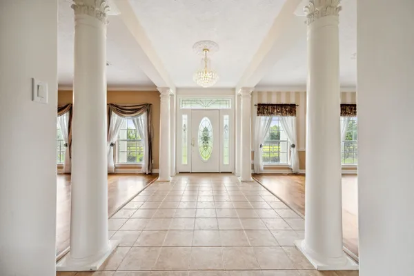 a view of a hallway with windows and chandelier