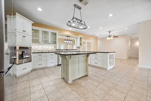 a kitchen with stainless steel appliances granite countertop a stove top oven a sink a counter space and cabinets