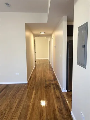 a view of a hallway with wooden floor