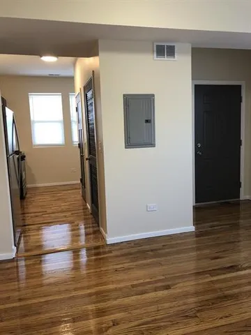 a view of empty room with wooden floor