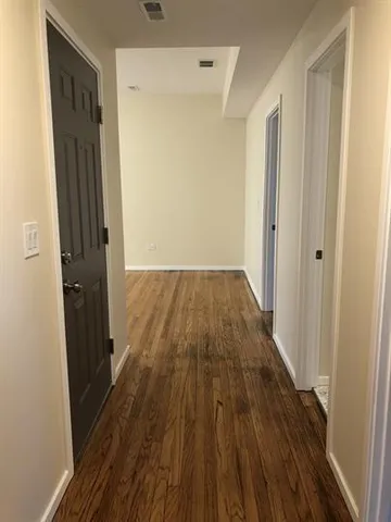 a view of a hallway with wooden floor