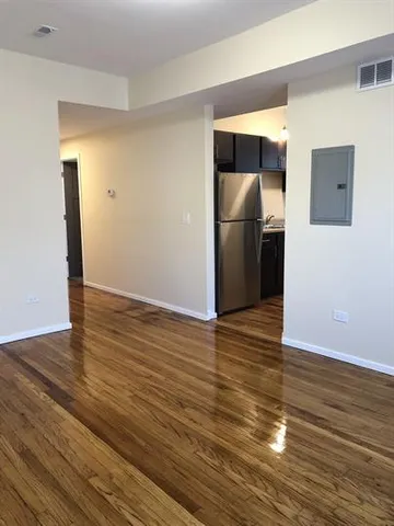 a view of empty room with wooden floor