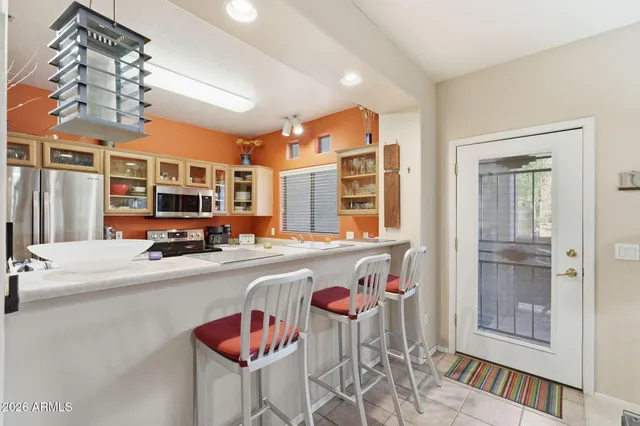 a kitchen view with stainless steel appliances granite countertop a dining table chairs and couches