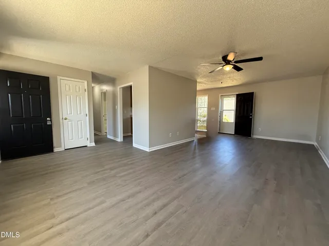 a view of a livingroom with a flesh screen tv and staircase