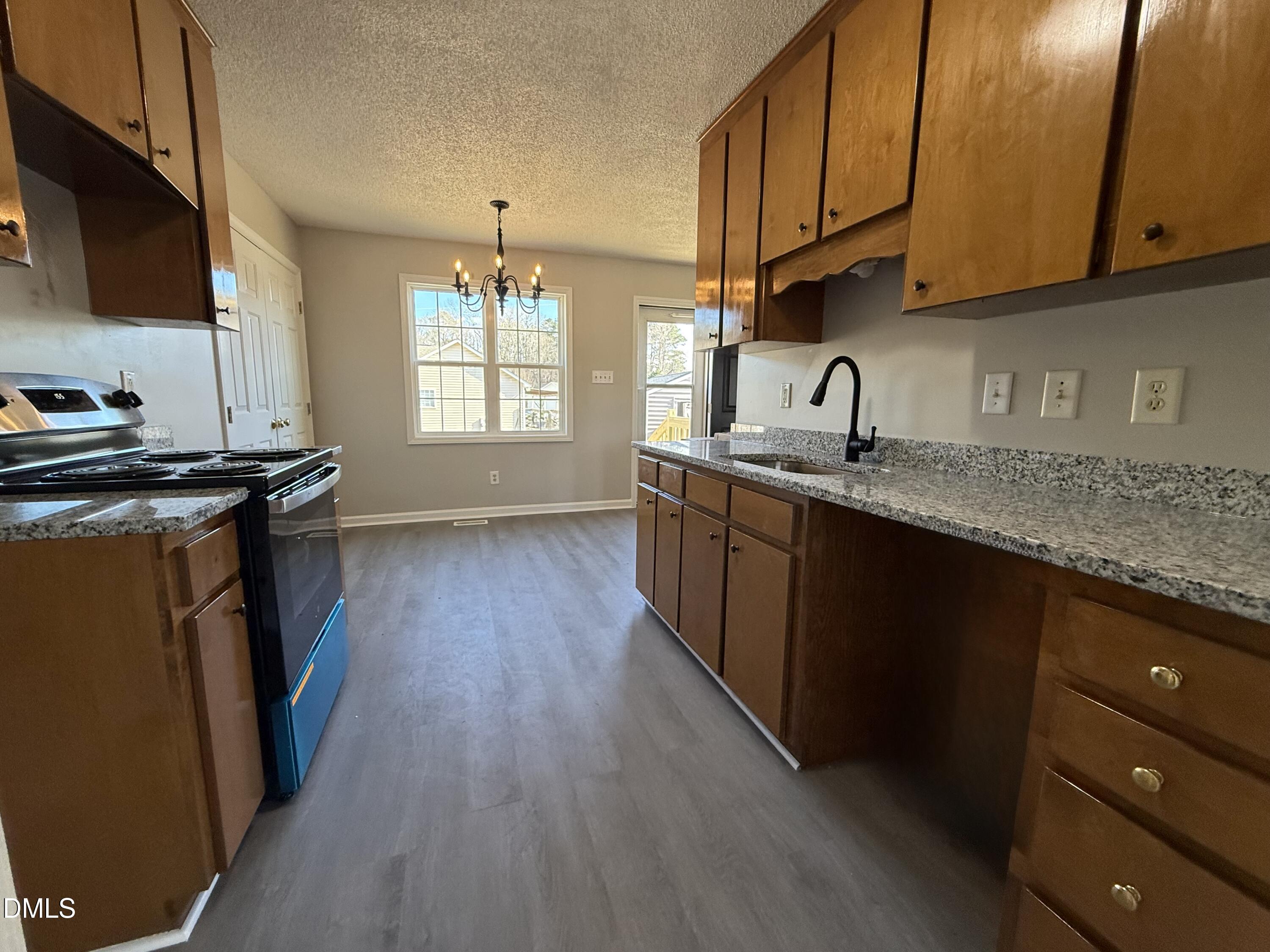 101 Copper Stone Street Smithfield, NC 27577 - Photo 25 of 32 a kitchen with a sink a stove a microwave and cabinets