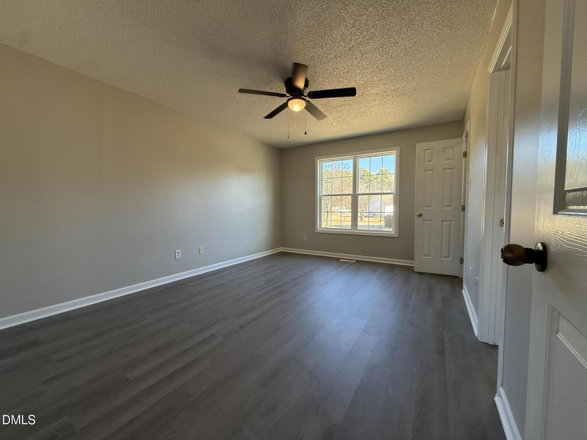 101 Copper Stone Street Smithfield, NC 27577 - Photo 26 of 32 an empty room with wooden floor fan and windows