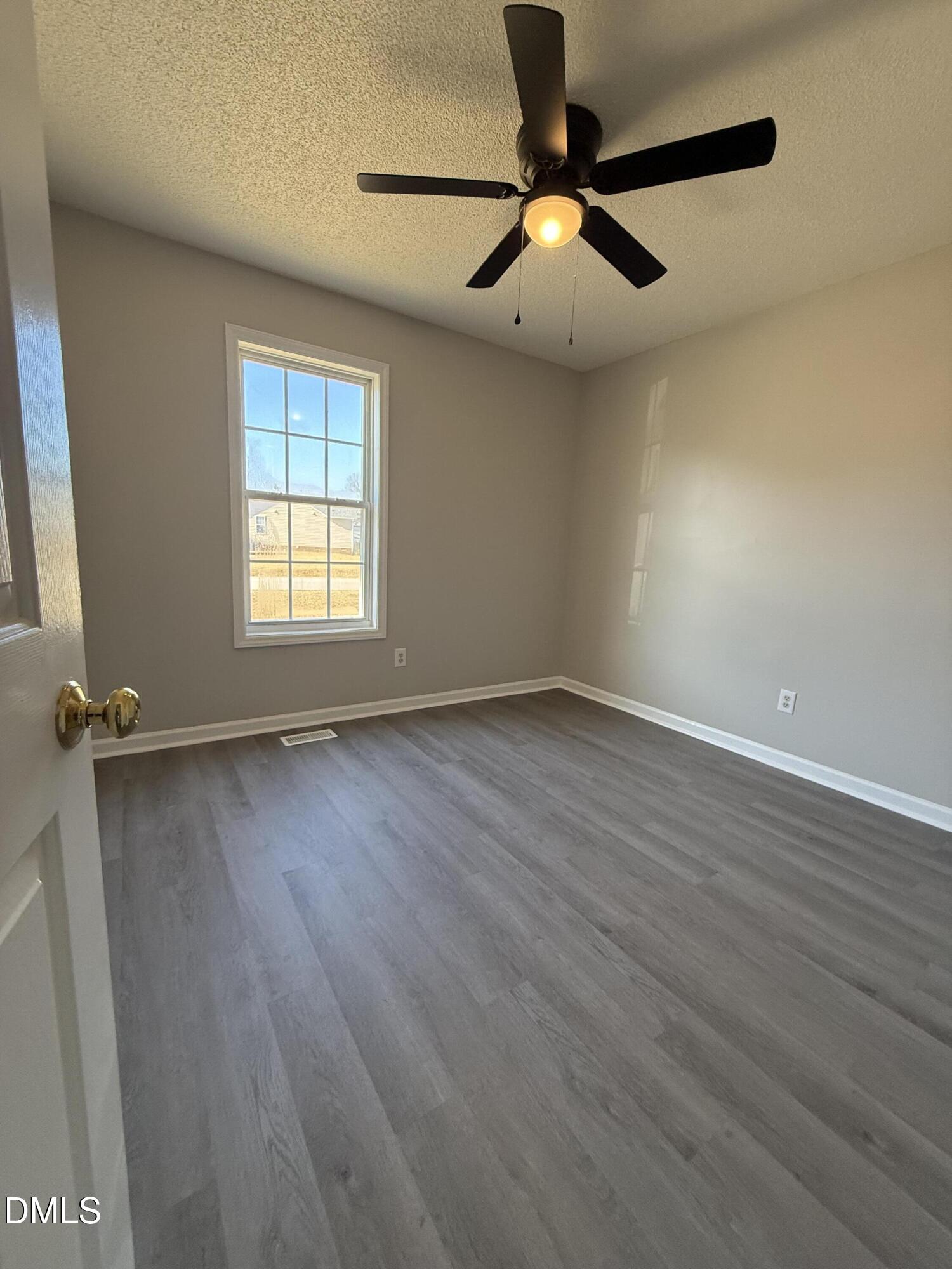 101 Copper Stone Street Smithfield, NC 27577 - Photo 29 of 32 wooden floor in an empty room with a window