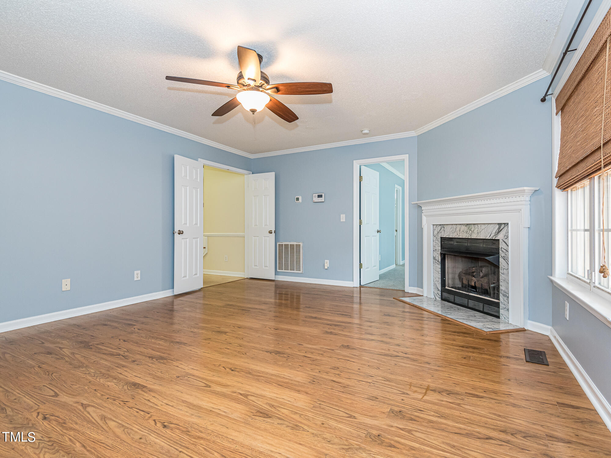 33 Troy Drive Clayton, NC 27520 - Photo 4 of 37 a view of an empty room with wooden floor fireplace and a window