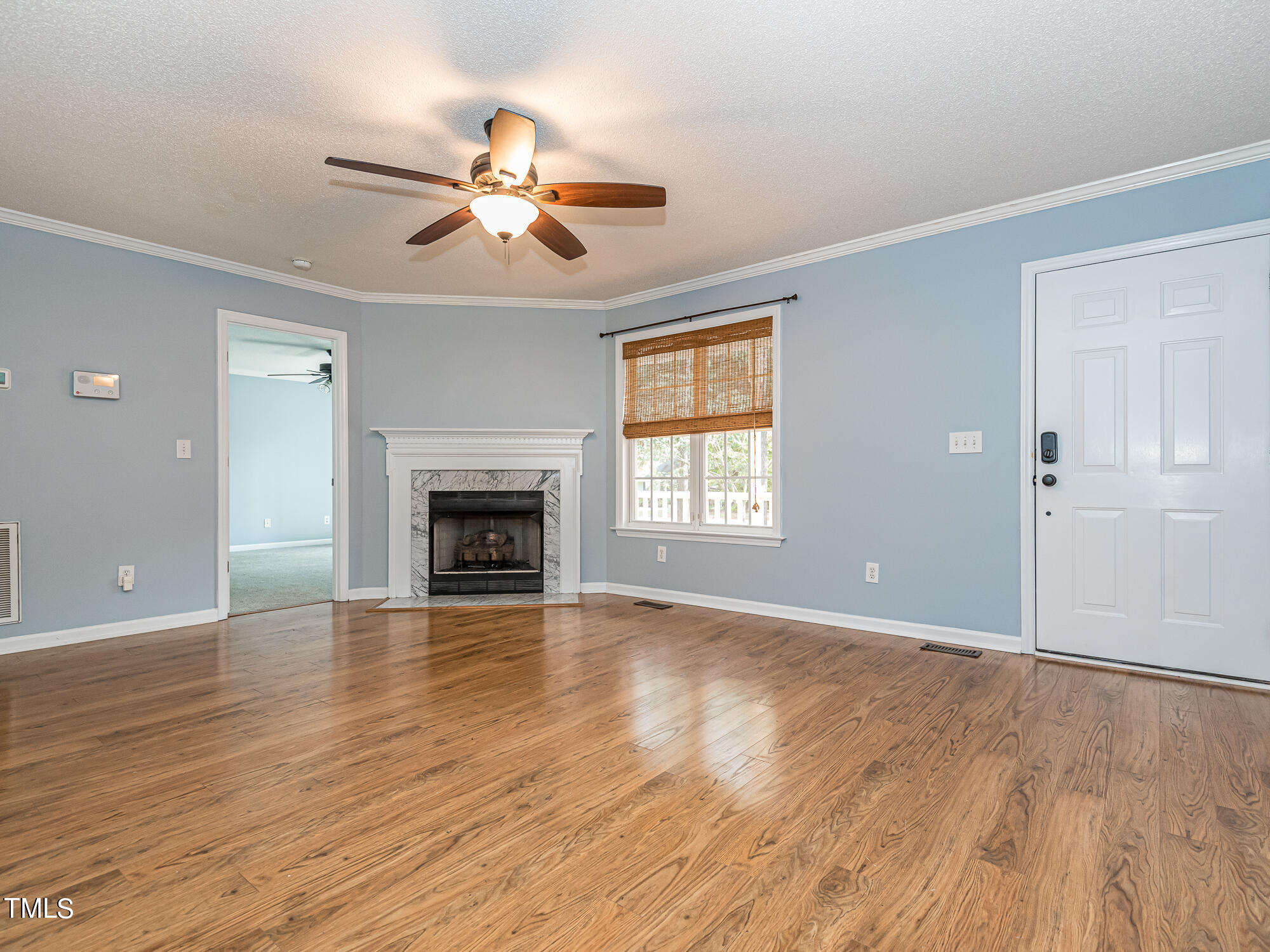 33 Troy Drive Clayton, NC 27520 - Photo 5 of 37 a view of an empty room with wooden floor fireplace and a window