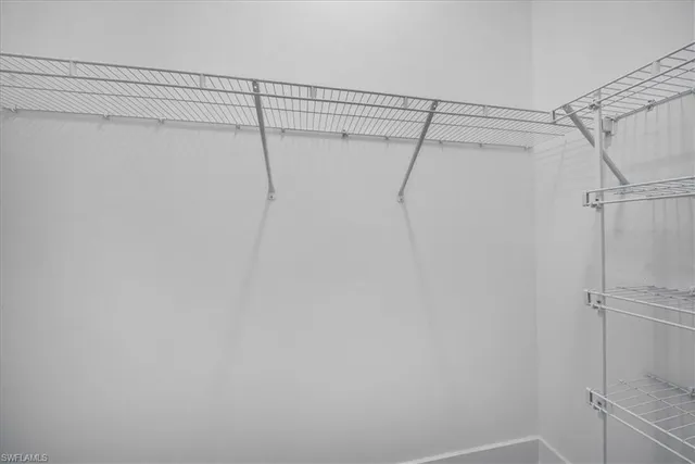 an empty room with a ceiling fan and window