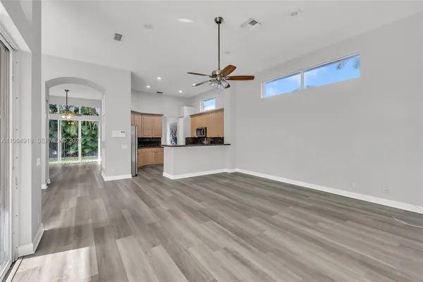a view of a kitchen with wooden floor and a ceiling fan