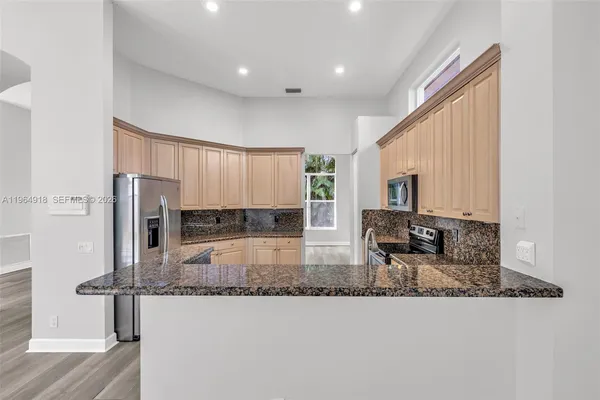 a kitchen with sink refrigerator and microwave